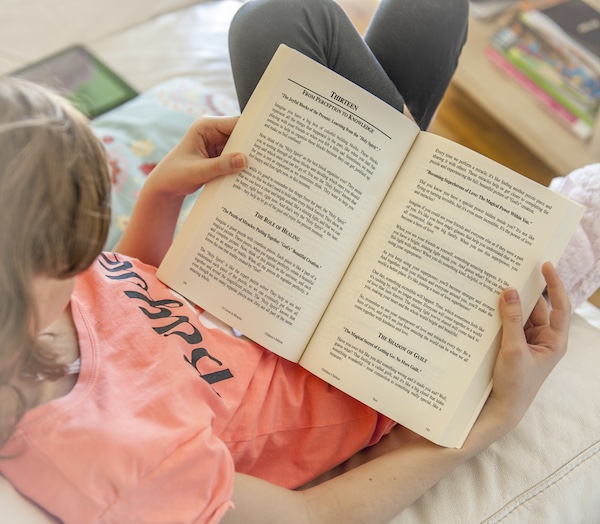 young lady reading chapter thirteen of A Course in Miracles, children's edition